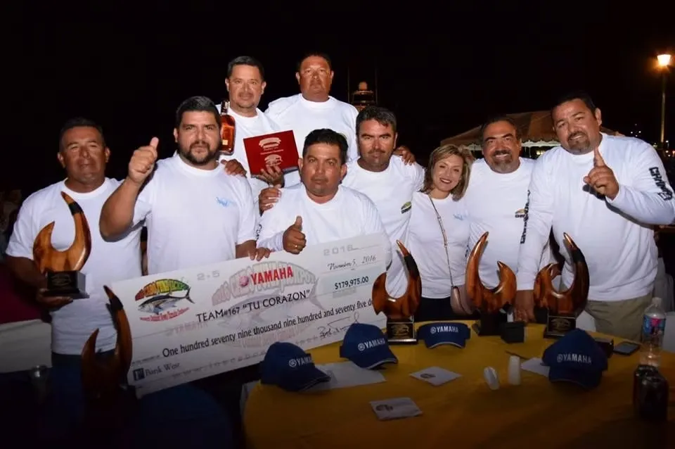 Team Tu Corazon holding the winning check